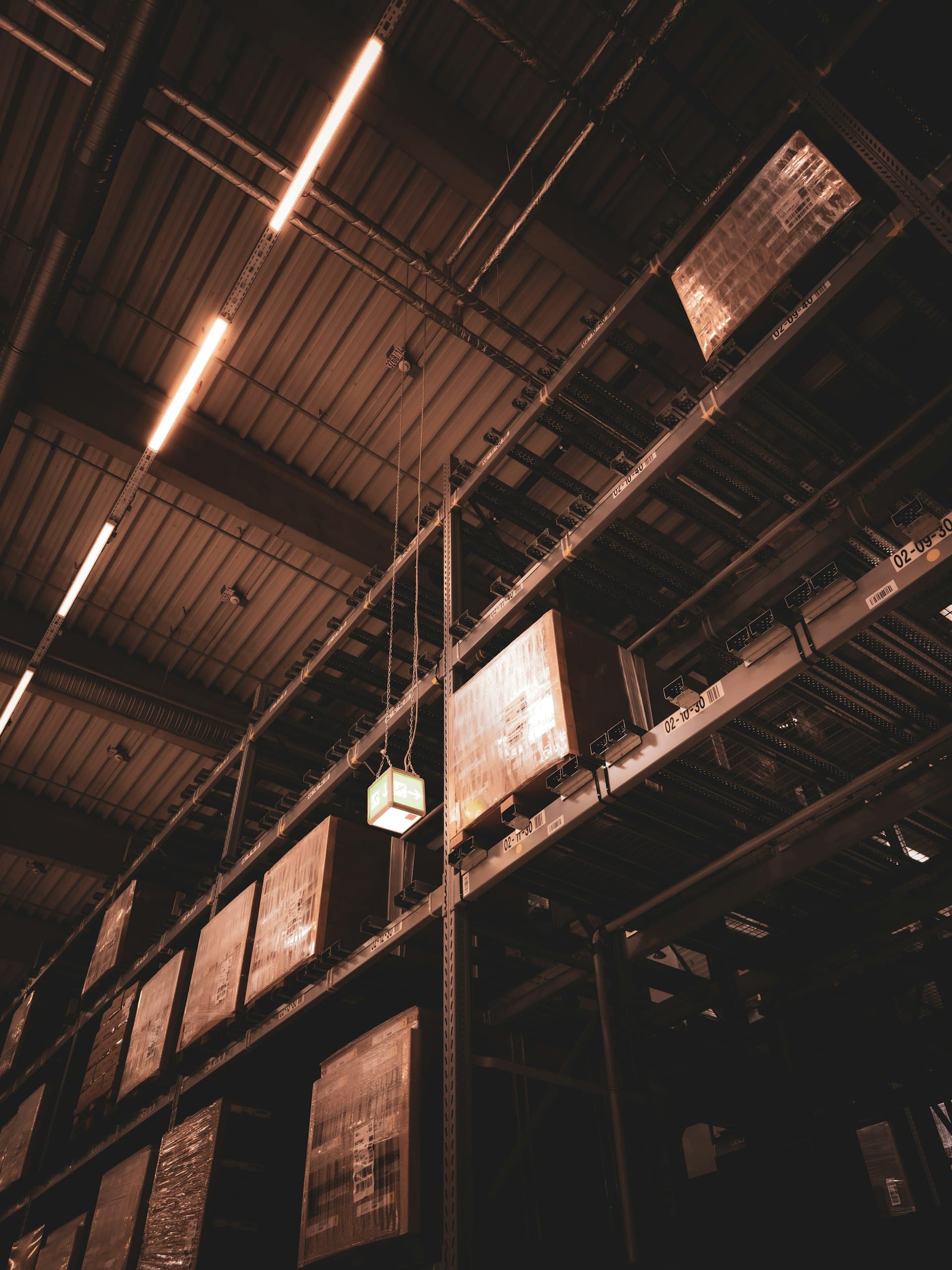Looking up at the steel ceiling structure and high racking of a warehouse interior